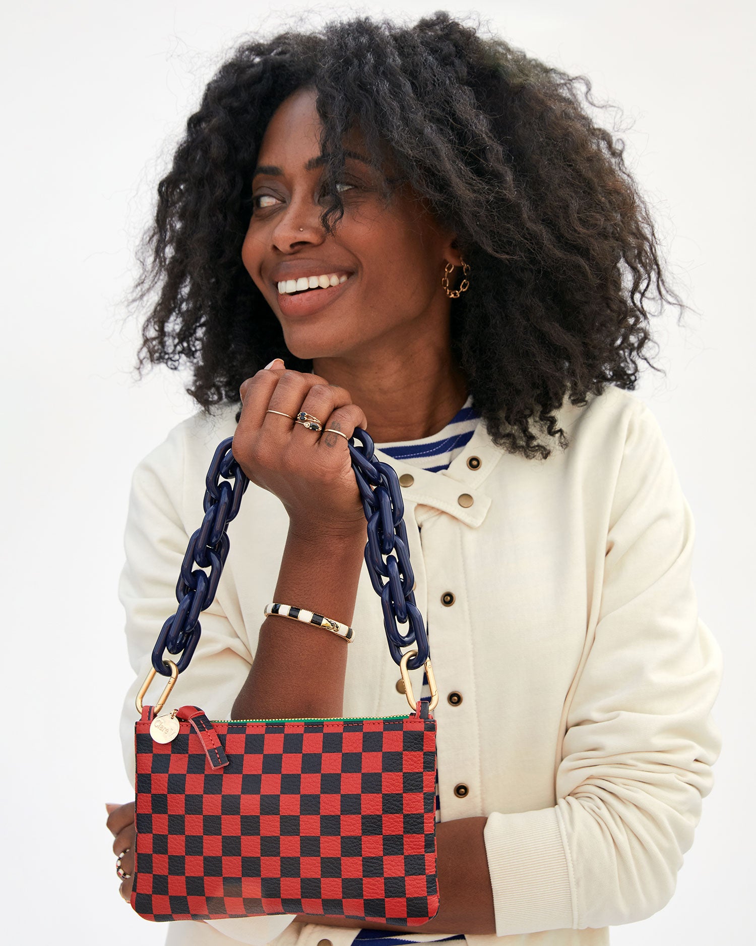 mecca in a white jacket carrying the Red and Navy Checker Wallet Clutch w/ Tabs  by the navy resin shortie strap